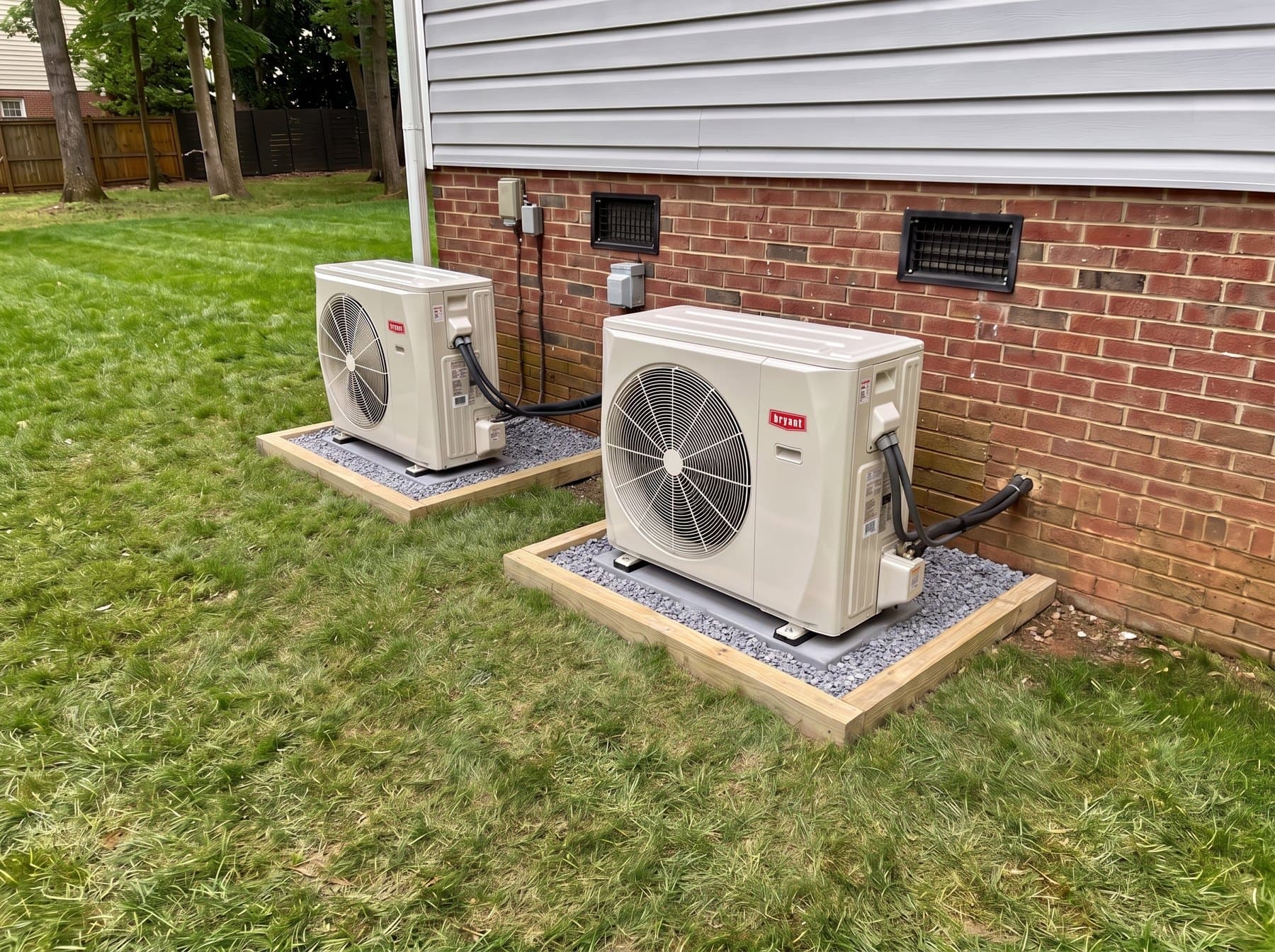 Two Bryant outdoor units side by side on a shared gravel pad