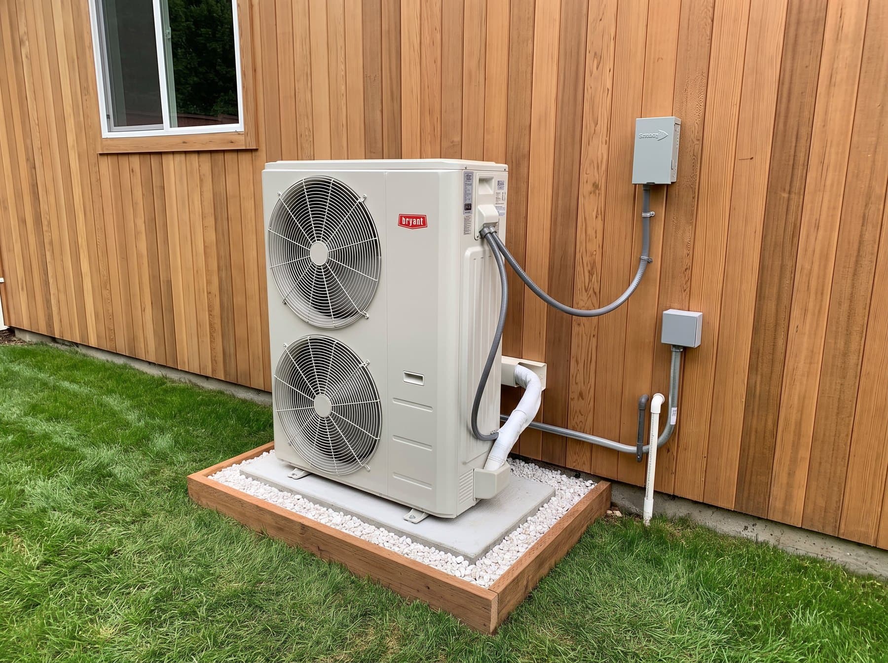 Bryant outdoor unit with disconnect box against a cedar-clad wall